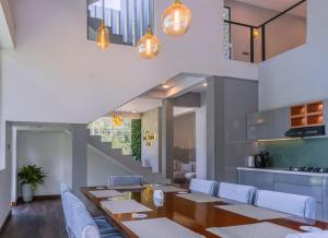 a dining room with a table and chairs and a staircase at The cloud ella in Ella