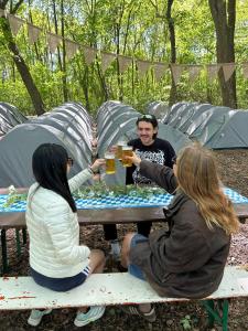 a group of people sitting at a picnic table with drinks at Munich Oktoberfest Accommodation Party Camping Experience in Munich