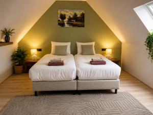 a bedroom with a large bed in a attic at Hotel de Koningsherberg in Anloo