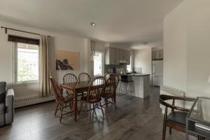 a kitchen and dining room with a table and chairs at Downtown - FREE shuttle to Ski Resort - Ice Rink in Mont-Tremblant