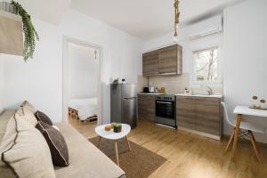 a living room with a couch and a kitchen at Ourania Lofts and Suites in Thessaloniki