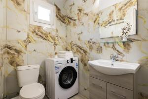 a bathroom with a washing machine and a sink at Ourania Lofts and Suites in Thessaloniki