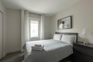 a bedroom with a bed with two towels on it at Downtown - FREE shuttle to Ski Resort - Ice Rink in Mont-Tremblant