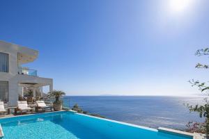 a villa with a swimming pool next to the ocean at Candia Lux in Heraklio +106 photos