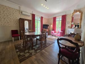 a living room with a dining room table and chairs at Villa Honorine in Saint-Honoré-les-Bains