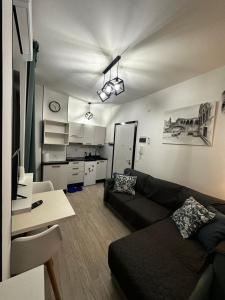 a living room with a couch and a kitchen at Appartamento Antares Piazza Fontana in Lignano Sabbiadoro