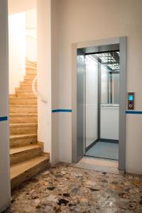 an empty hallway with stairs and a glass door at Appartamento Antares Piazza Fontana in Lignano Sabbiadoro