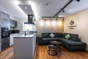 a living room with a couch and a kitchen at Eifel Comfort Luxury Spa Suite mit privatem Whirlpool & Sauna in Pronsfeld +30 photos