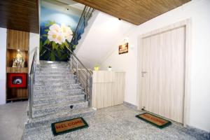 a staircase with a door and a flower painting on the wall at Nahor Residency in Guwahati