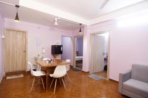 a living room with a table and chairs and a couch at Nahor Residency in Guwahati