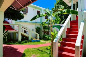 a stairway leading up to a building with red stairs at Harmonia - Sunbeha resort, Juan Dolio in Juan Dolio