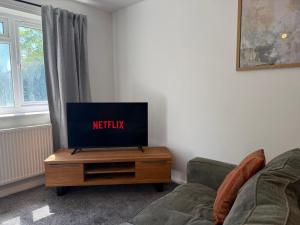 a living room with a tv on a table at Gatwick 2 Bed Apartments Free Parking in Horley