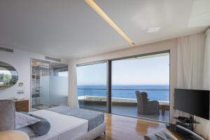 a bedroom with a view of the ocean at Candia Lux in Heraklio
