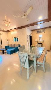 a living room with a glass table and chairs at Rustic Farm Villa in Chinchavli