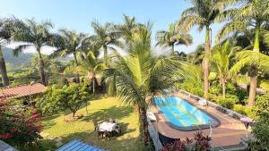 an aerial view of a resort with a swimming pool and palm trees at Rustic Farm Villa in Chinchavli