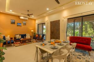 a living room with a table and a red couch at EKOSTAY - Brick Wood in Karjat