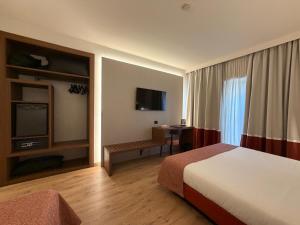 a hotel room with a bed and a television at Mokinba Hotels Baviera in Milan