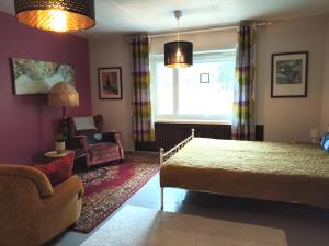 a bedroom with a bed and a living room at Kotamäen Wanha Koulu in Pieksämäki