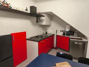 a kitchen with red cabinets and a stove top oven at Agli Archi Eco House in Chieti