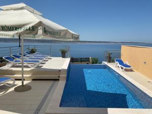 a swimming pool with lounge chairs and an umbrella at Villa Luna Maris in Starigrad