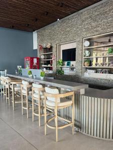 a restaurant with a bar with stools and a brick wall at 18 El escape perfecto frente al mar in Santa Marta