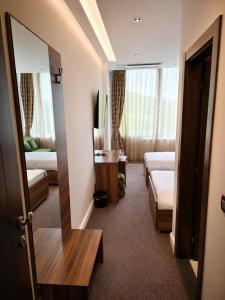 a hotel room with two beds and a mirror at Hotel Luka's in Berane