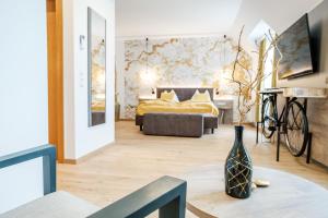 a room with a bed and a table with a vase at Landhotel Schwabenhof in Heiligenbrunn