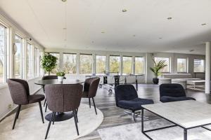 a room with a table and chairs and windows at Hakefjorden by Workershotel in Källsby