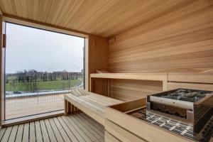 a sauna with a bench and a large window at eXo Fly Level 4 Hotel Stuttgart-Flughafen in Ostfildern