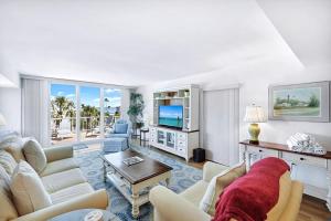 a living room with white furniture and a view of the ocean at Lighthouse Point A311 in Sanibel