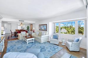 a living room with white furniture and a large window at Lighthouse Point A311 in Sanibel