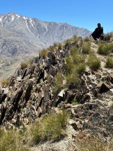 a man sitting on the side of a rocky mountain at Sidi hssain in Amizmiz