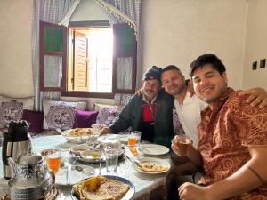 a group of men sitting around a table with food at Sidi hssain in Amizmiz