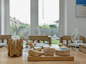 a wooden table with cheese and wine glasses on it at Stourcliffe House in Bournemouth