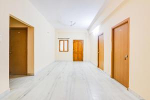 an empty corridor with wooden doors in an empty room at Hotel O Castle Inn Kondapur in Hyderabad