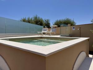 a pool on top of a building with two chairs at Casa Sautu-fau in Santa Venerina