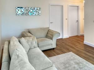 a living room with a couch and a chair at White Sands Cottage in Weymouth