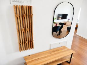a mirror on a wall with a table and a dining room at Apartmán Viktória in Poprad