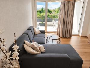 a living room with a blue couch with a teddy bear at Apartmán Viktória in Poprad