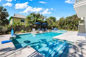 a pool with chairs and umbrellas in a house at Cabana Blu in Captiva