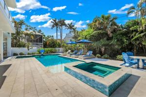 a swimming pool in a backyard with blue chairs at Cabana Blu in Captiva +31 photos