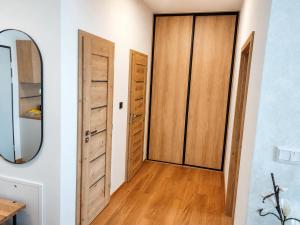a hallway with wooden doors and a mirror at Apartmán Viktória in Poprad +13 photos