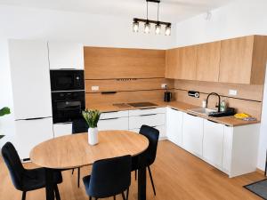 a kitchen with a table and chairs and a sink at Apartmán Viktória in Poprad