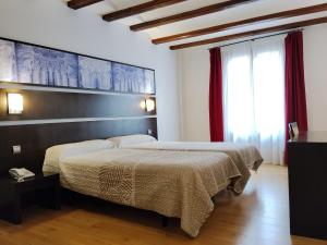a bedroom with a bed and a large window at Hotel Rey Sancho in Navarrete