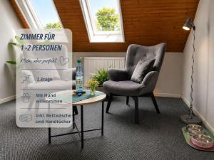 a room with a chair and a table with pillows at Zimmer Haus Krabbe für Kurzaufenthalt und Geschäftsreise, zwischen Bremerhaven und Cuxhaven in Wremen