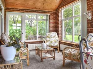 a living room with chairs and tables and windows at Quail Cottage - Uk50659 in Little Singleton