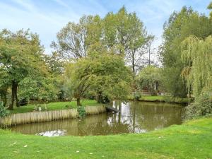a pond in a park with trees and a river at Quail Cottage - Uk50659 in Little Singleton +12 photos
