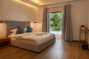 a bedroom with a large bed and a large window at Arena Blanca in Rasdhoo