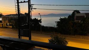 a street with a view of the ocean at sunset at Hermes View in Kavála