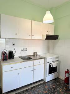 a kitchen with white cabinets and a sink at Hermes View in Kavála +15 photos